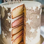 Close-up of a gender reveal cake with glittery accents and hidden colored filling