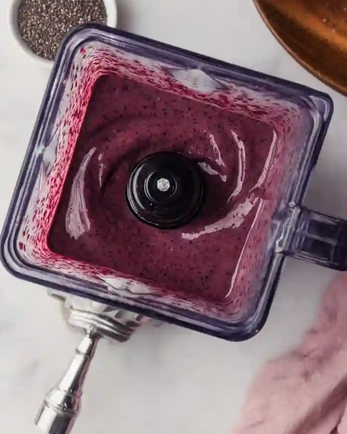 Blended chia seed smoothie with rich berry texture in a blender